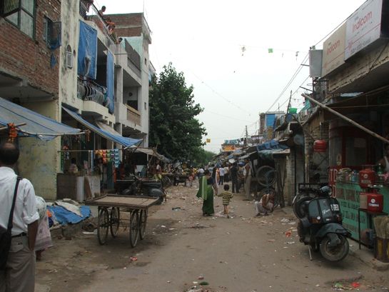 Road dividing legal slum on the left and illegal settlement on the right., Foto:  Ayona Datta